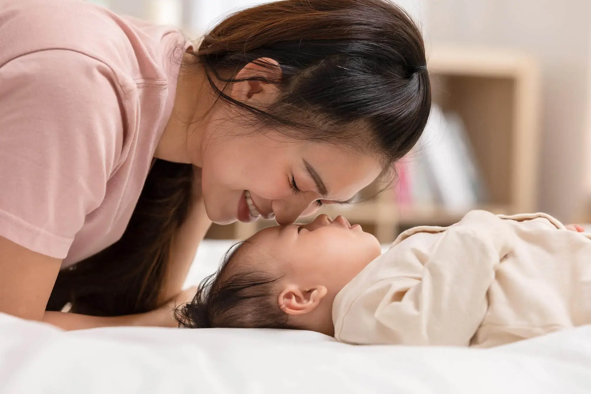 Mother kissing newborn baby after successful IVF treatment in Taiwan – IVF abroad cost comparison Singapore